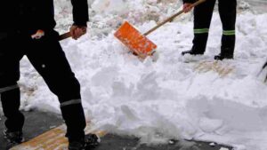 Workers clearing snow from Toronto sidewalks during winter storm operations