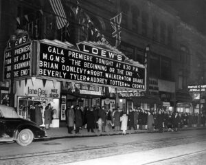 Historic black-and-white photo of people lined up outside Loew’s Theatre in Toronto during a 1940s movie premiere, with the bright marquee and downtown sidewalk crowd.