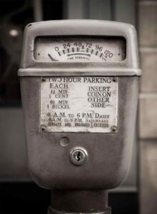 Vintage coin-operated parking meter used in Toronto during the 1950s showing time remaining dial and pricing