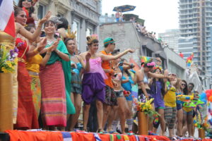 Pride Toronto parade participants and crowds celebrating on a downtown Toronto street.